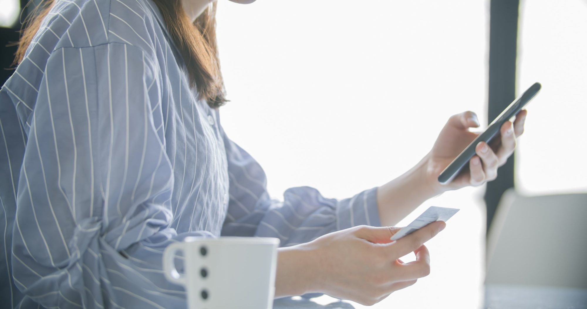 スマートフォンとクレジットカードを手にしている様子