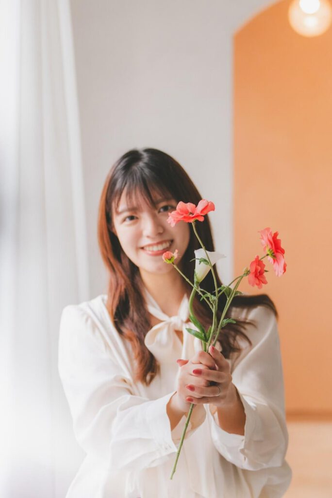 お花を持って微笑む西田のぞみ